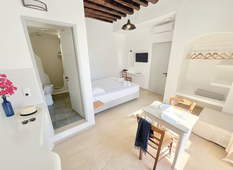 Open door to the en-suite bathroom, with dining table and hanging alcove