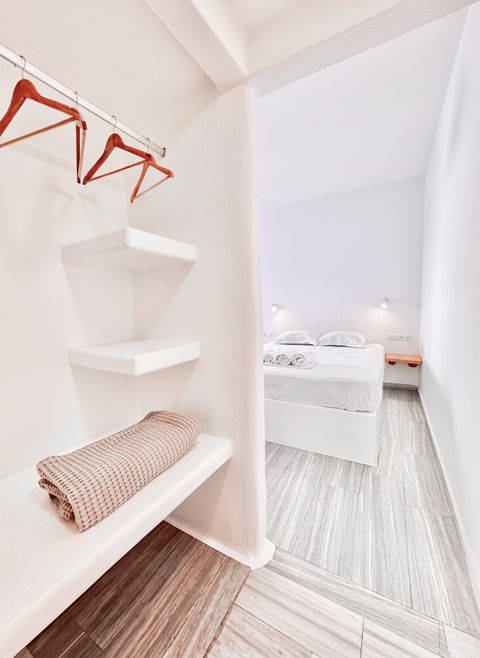Open hanging rail and shelves, with the double bed beyond