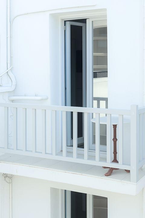 Private balcony with white wooden railing outside glazed doors