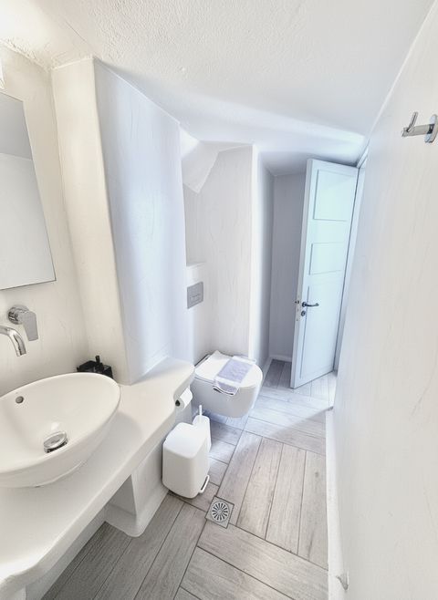 En-suite bathroom with vessel basin, wall-hung toilet and white plastered walls